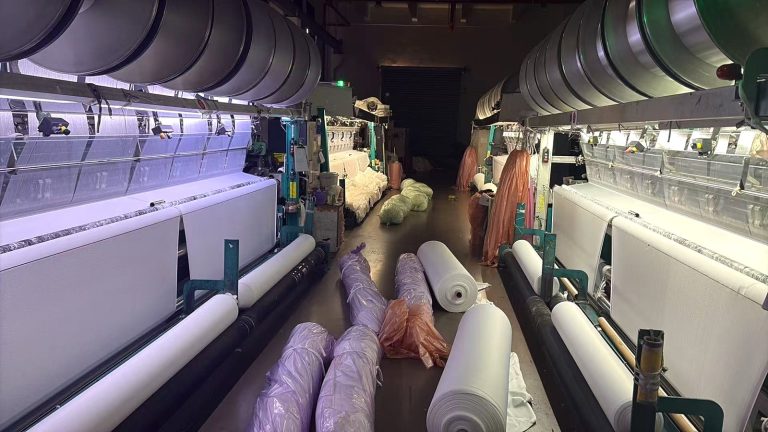 Production floor with knitting machines and fabric rolls